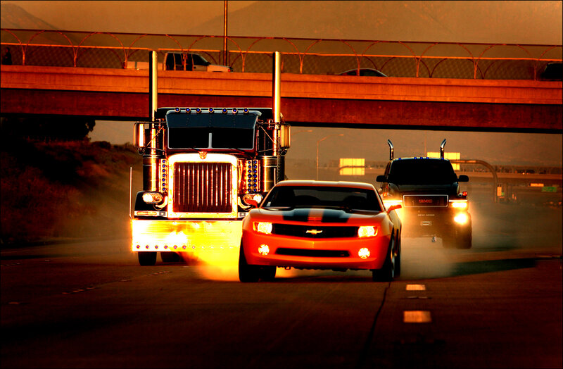 Trucks and cars on highway at sunset
