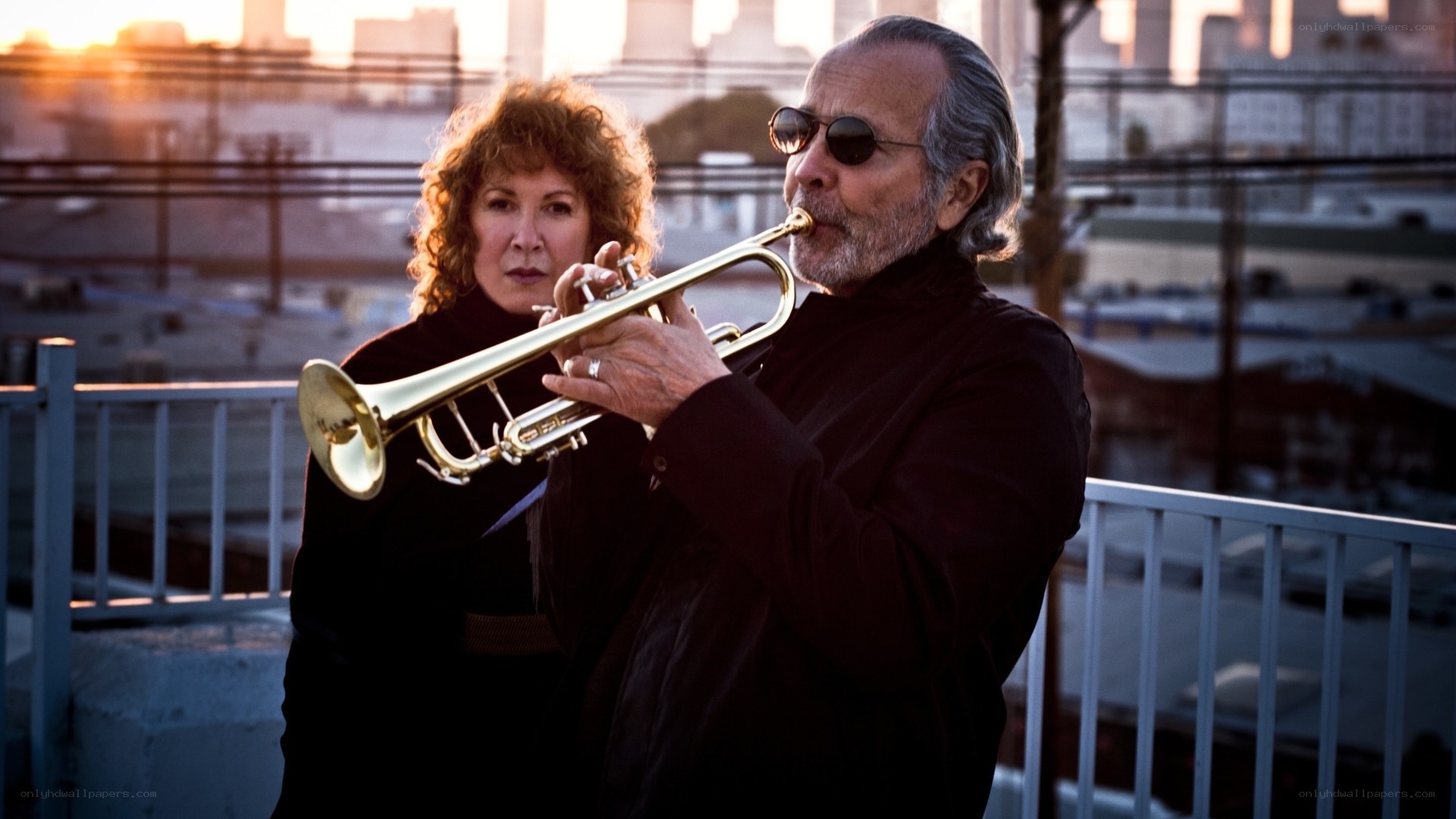 Trumpet player with woman on rooftop
