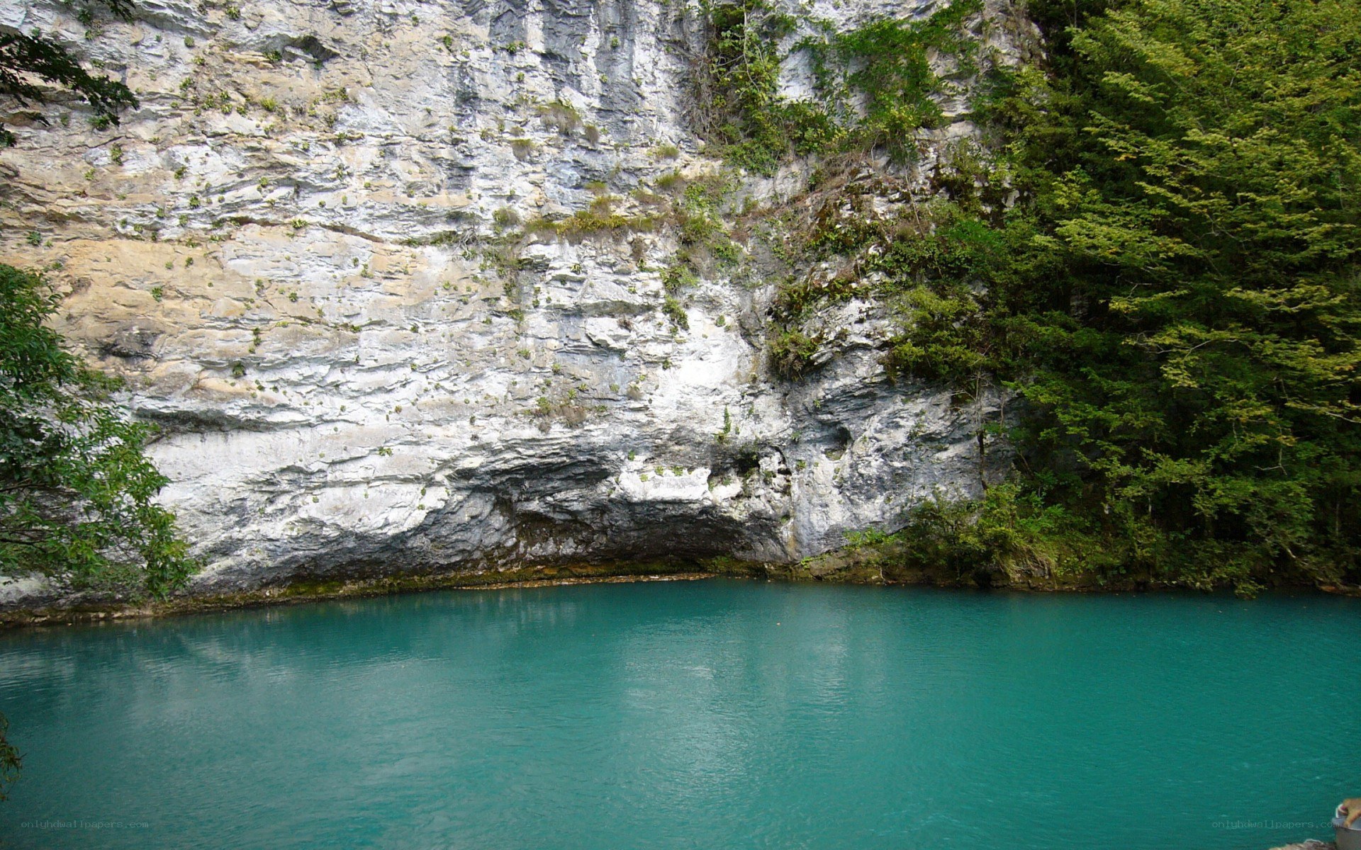 turquoise lake by a cliff