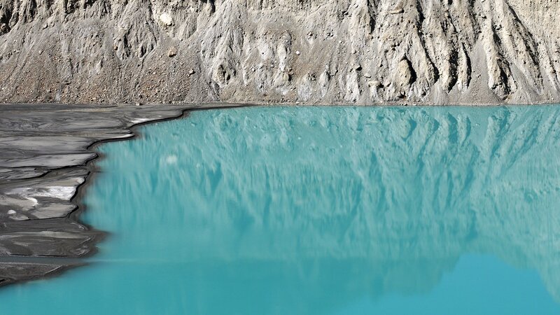 Turquoise lake reflecting cliffs