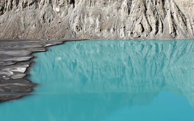 Turquoise lake with rock wall