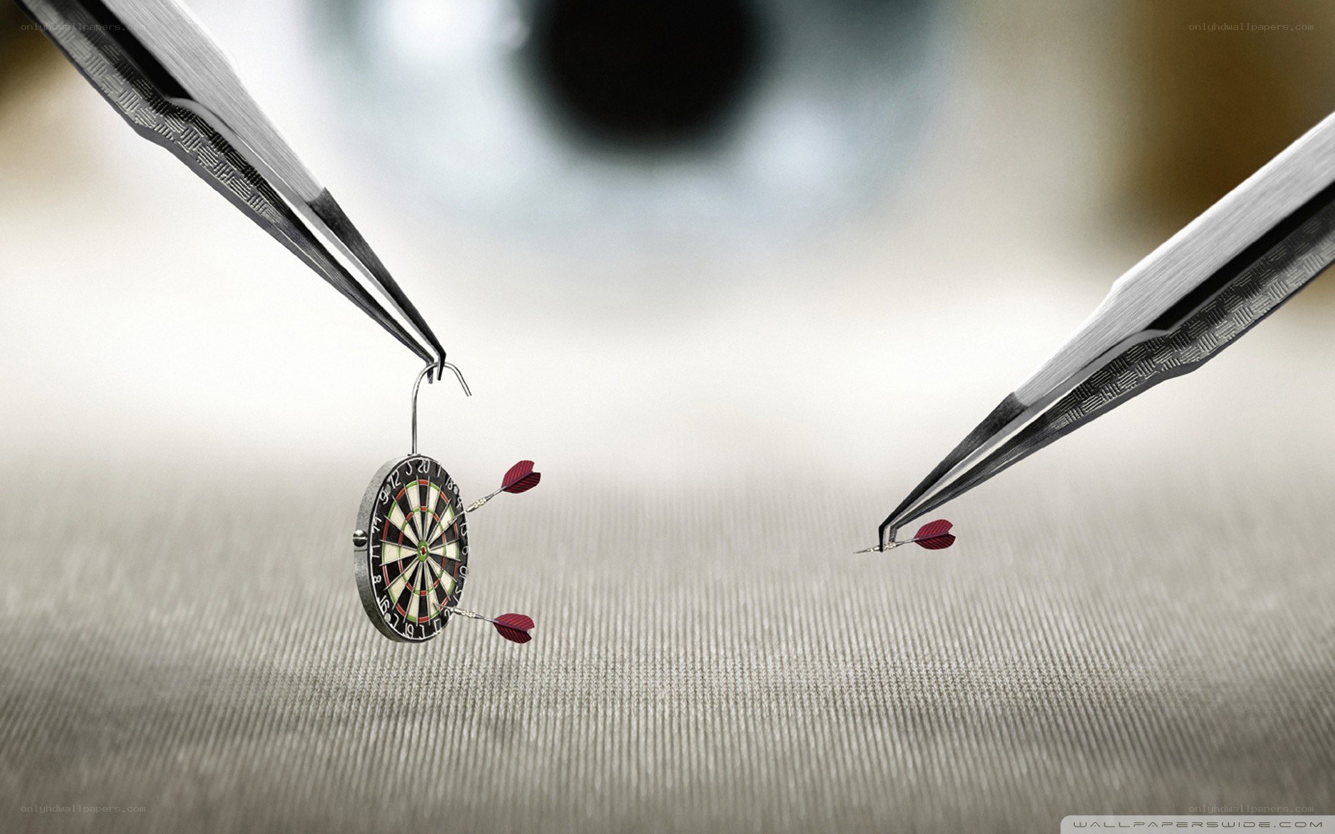 tweezers holding a dartboard