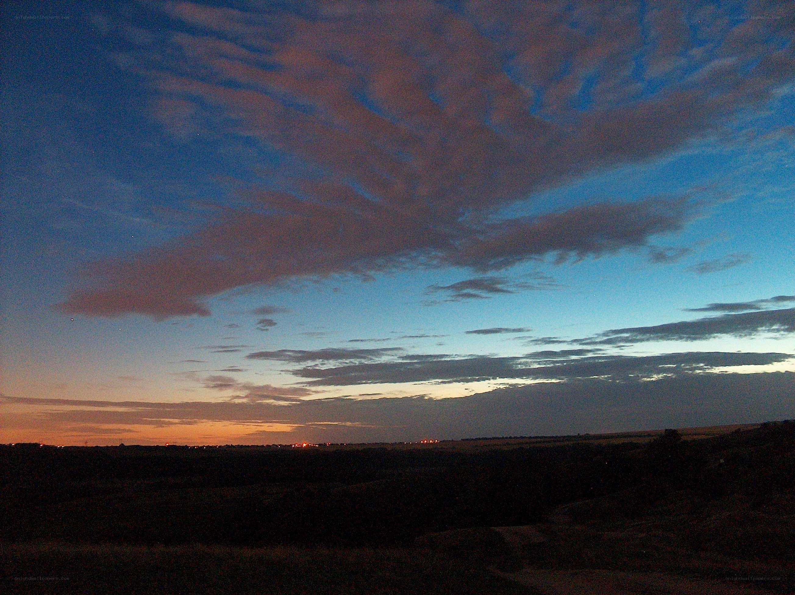 Twilight sky over a dark landscape
