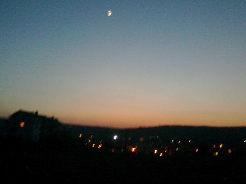 Twilight sky with moon and city lights