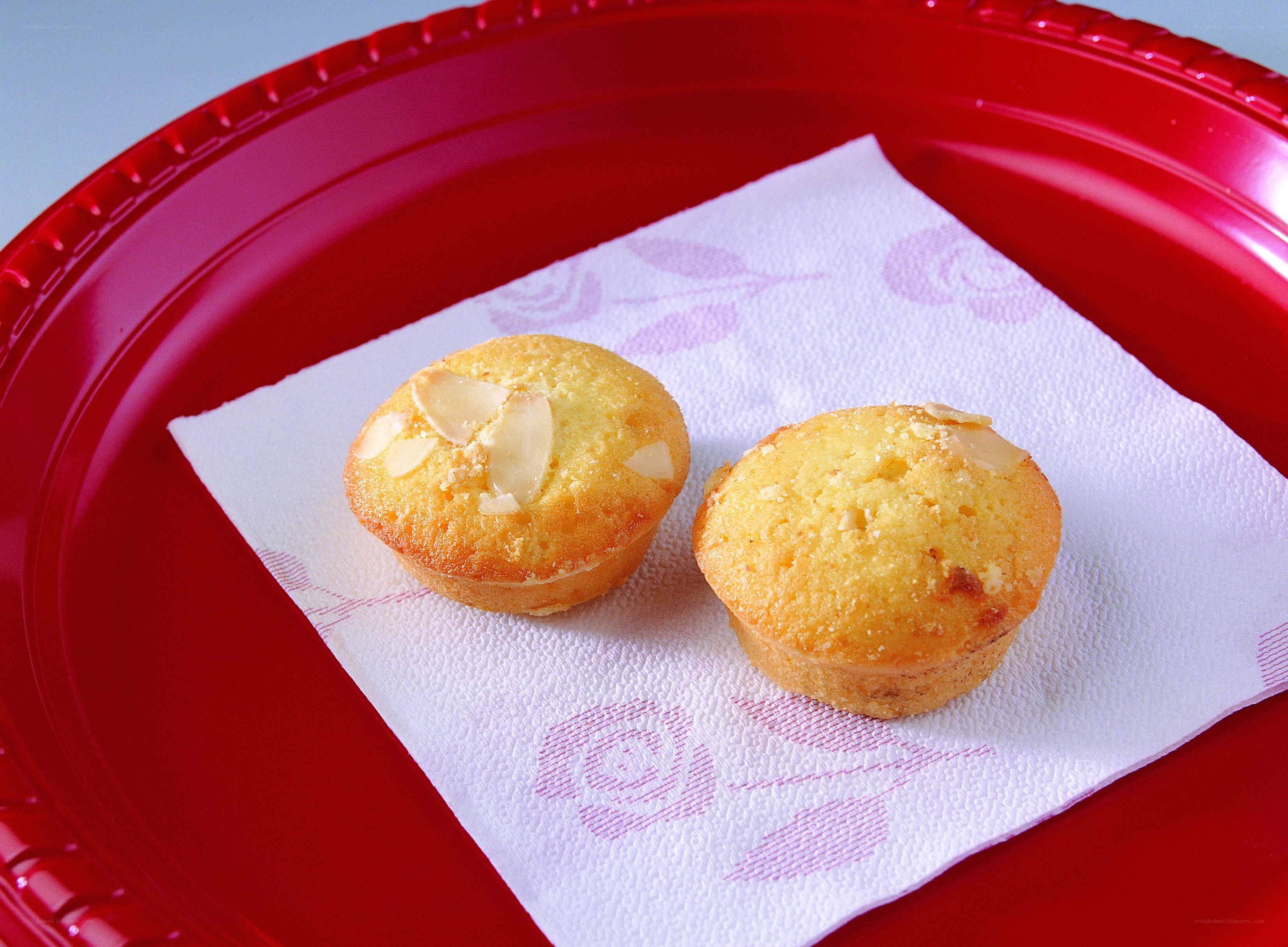 two almond muffins on a red plate
