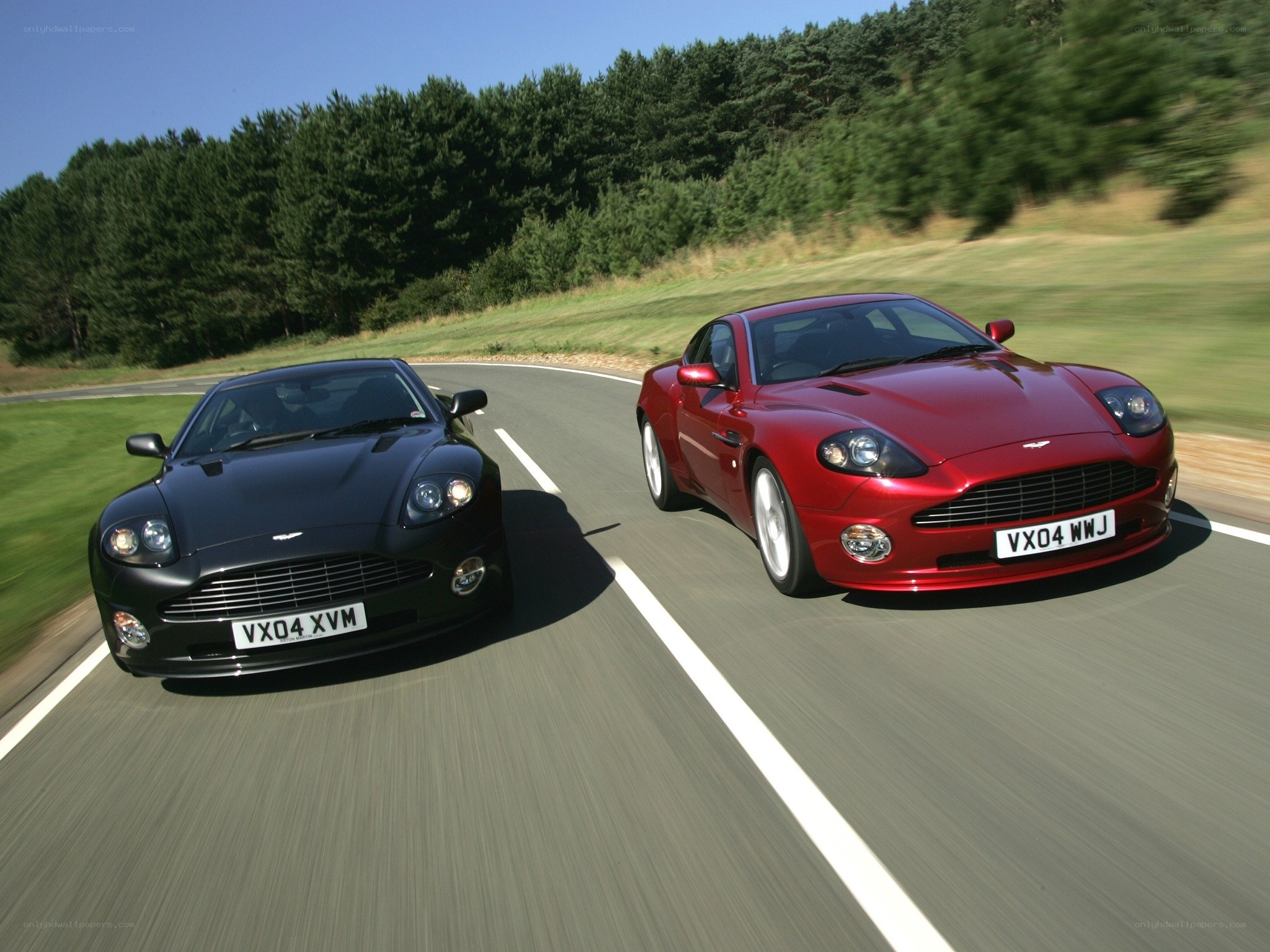 Two Aston Martin cars on a road