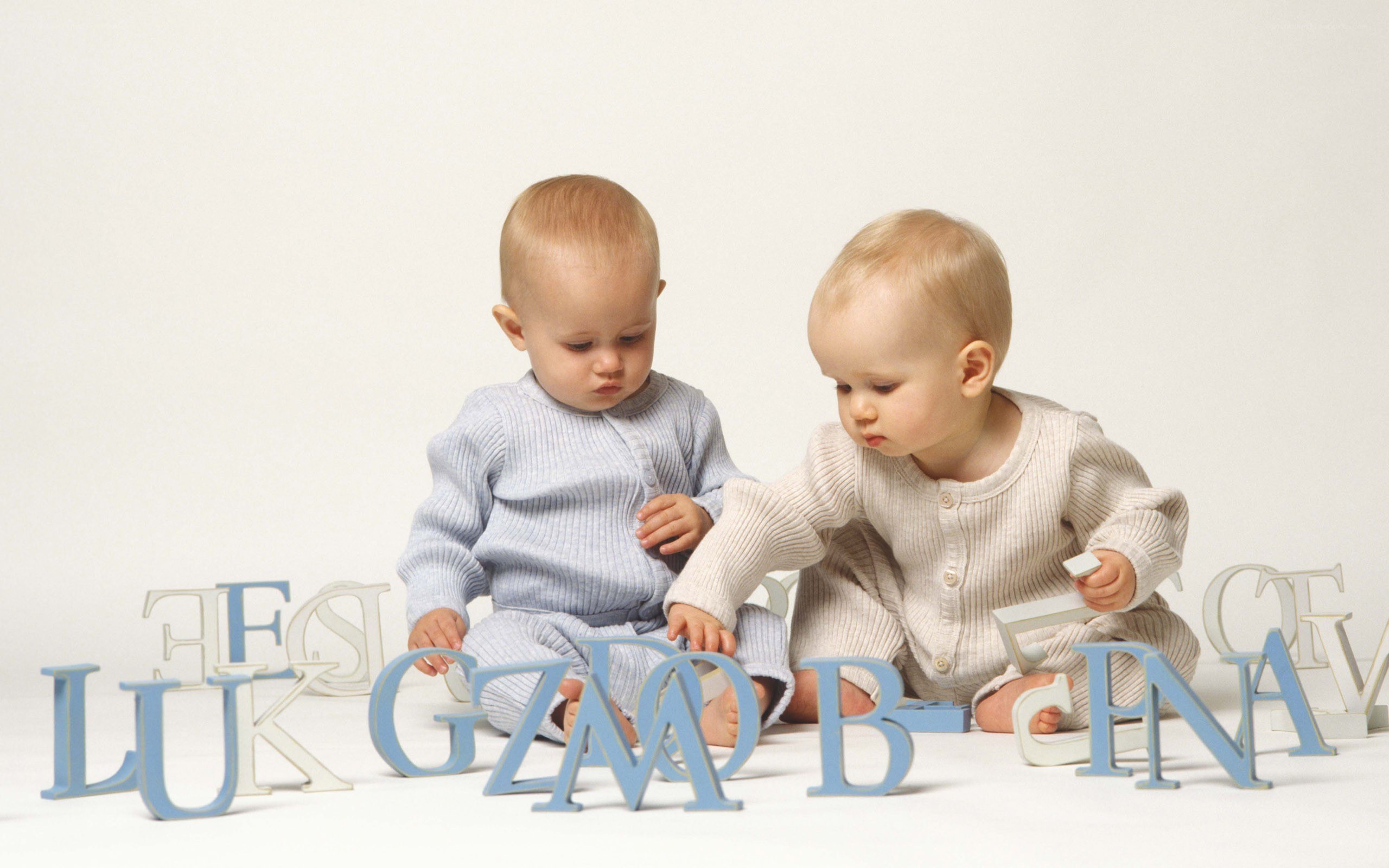 two babies playing with alphabet blocks