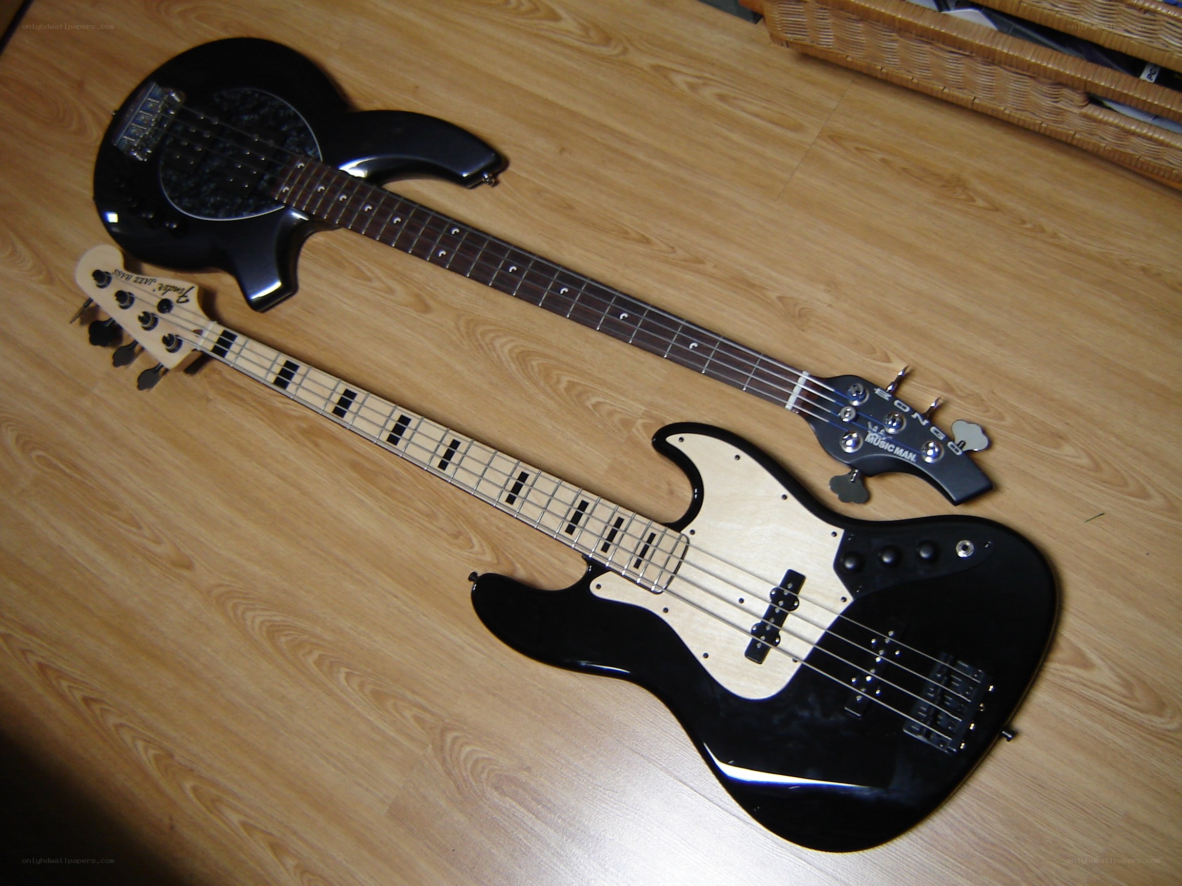 Two bass guitars on floor