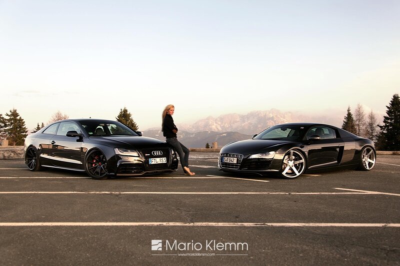 Two black Audis with a woman