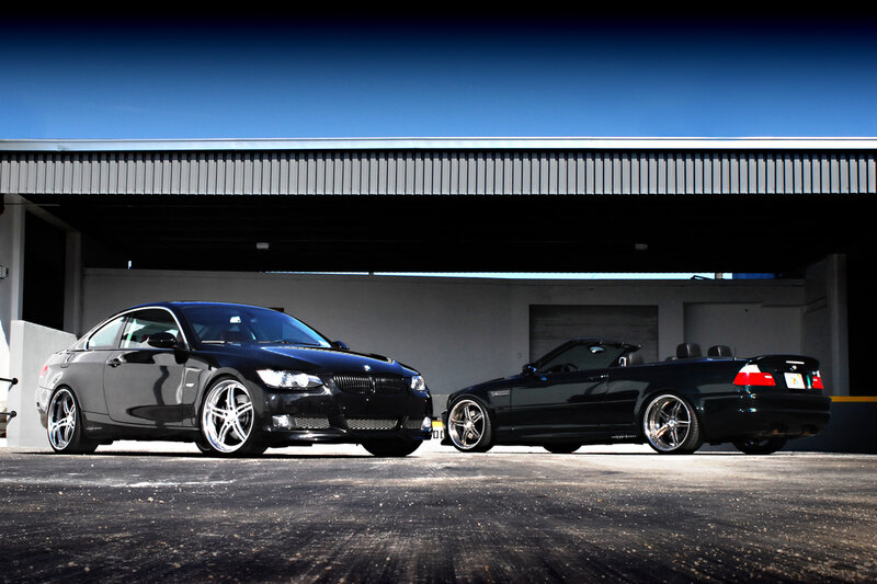 Two black BMWs parked
