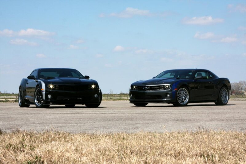 Two black Camaro cars on tarmac