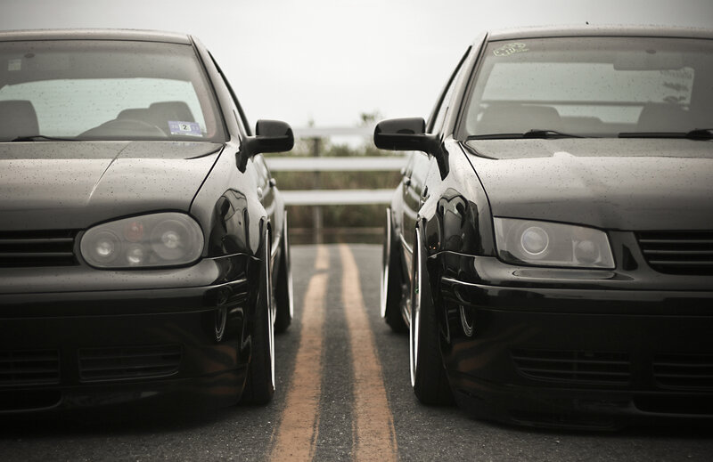 Two black cars on a road