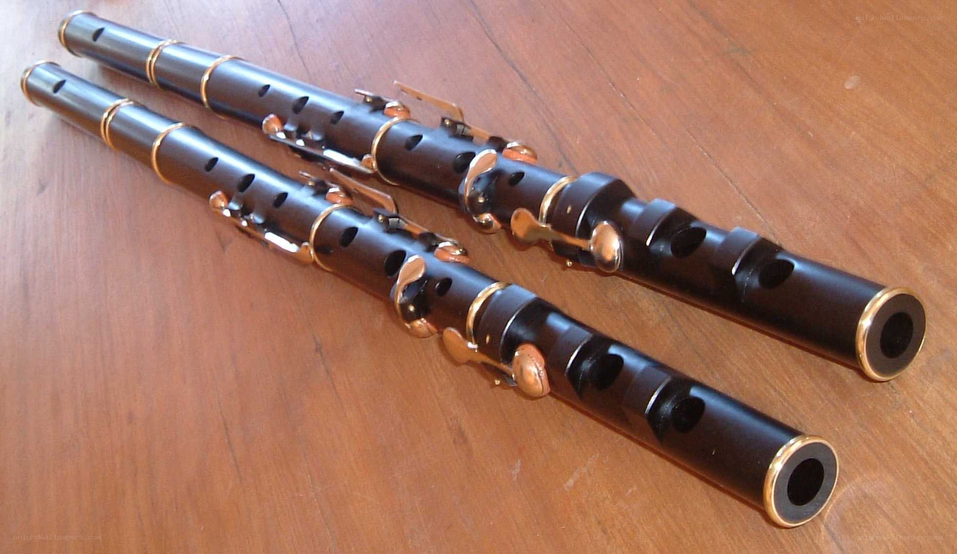 Two black flutes on wood