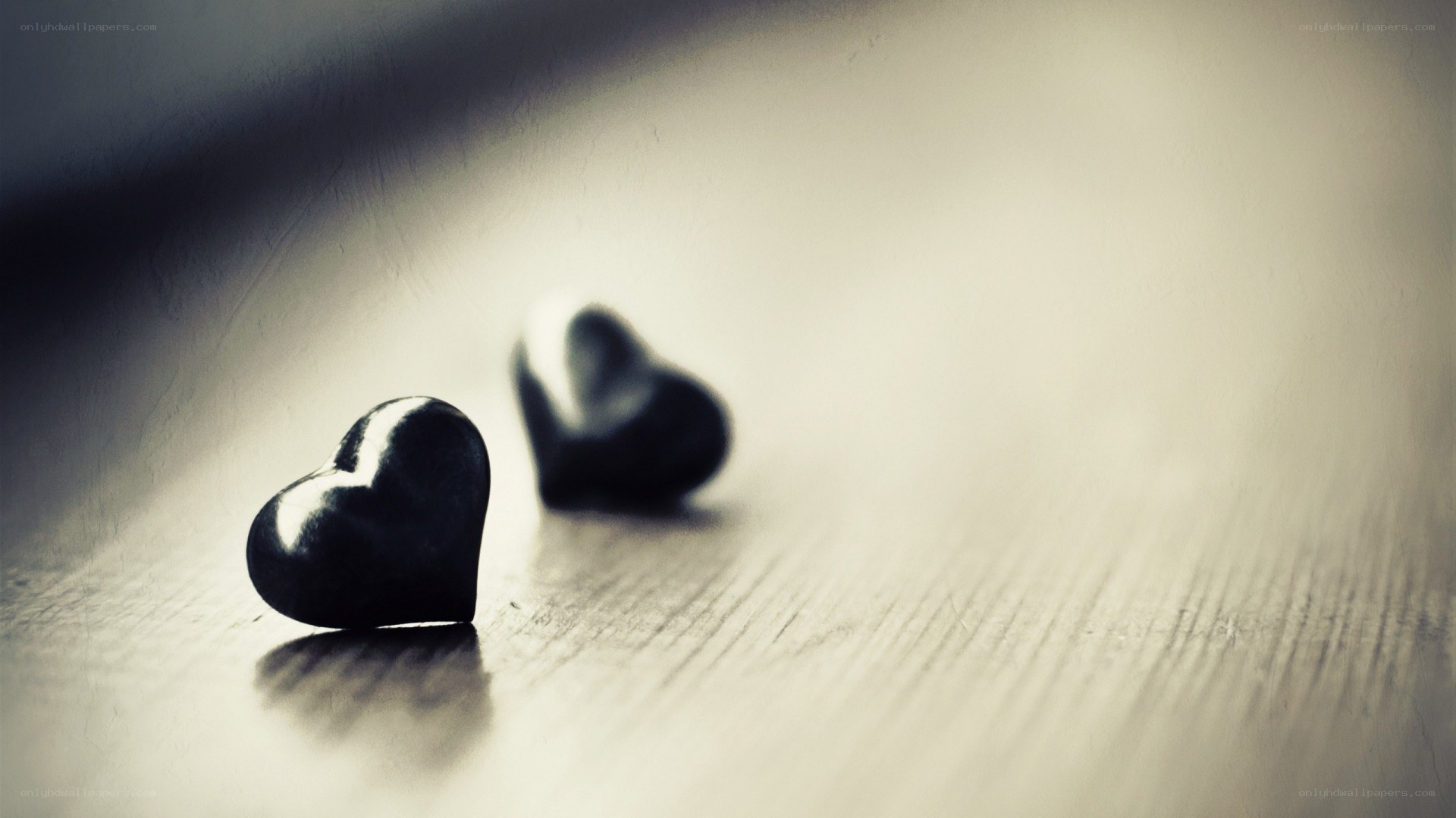 Two black hearts on wood