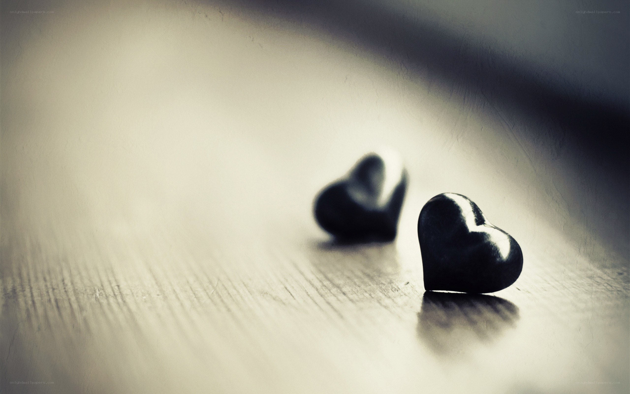 Two black hearts on wood