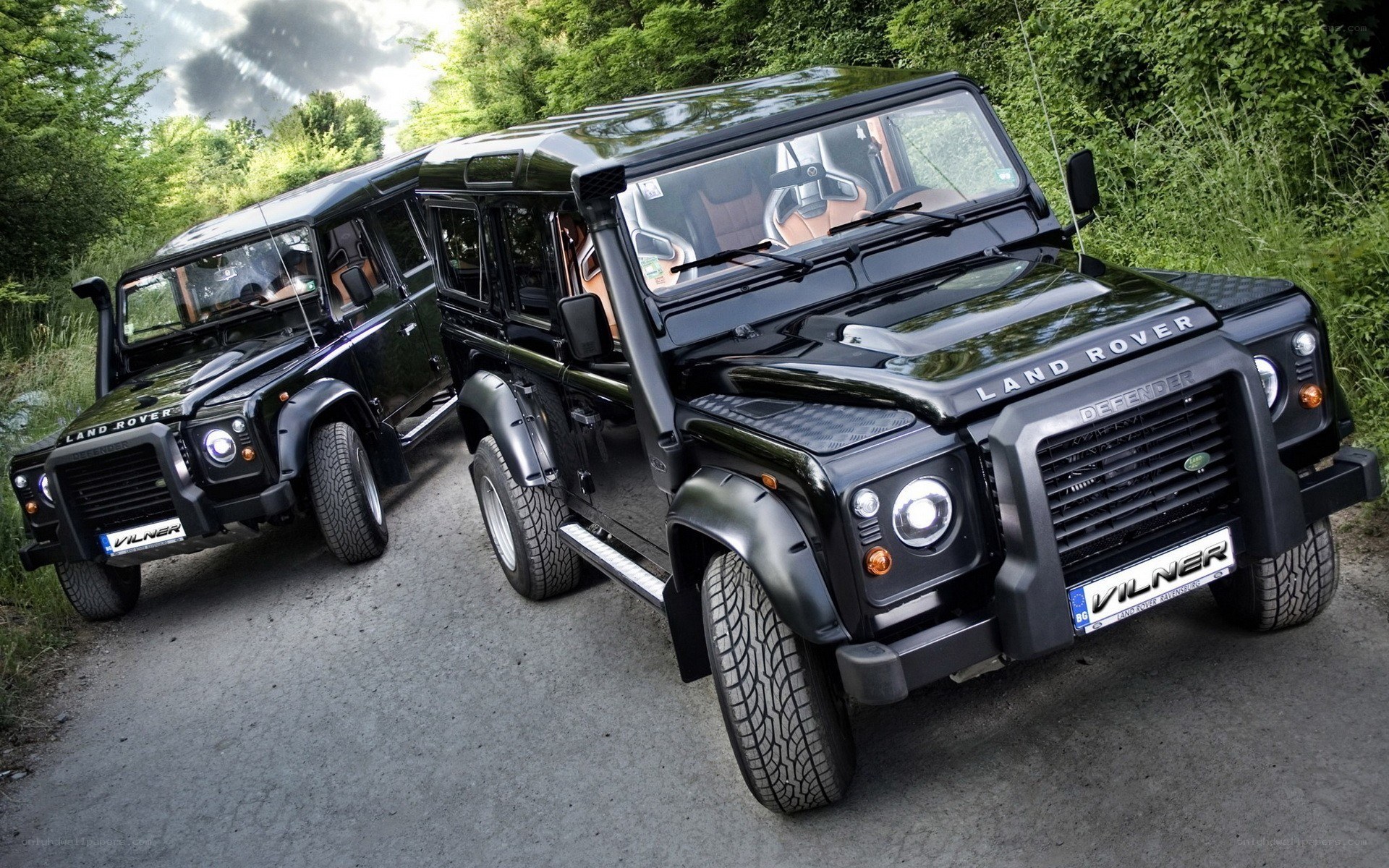 Two black Land Rover Defenders