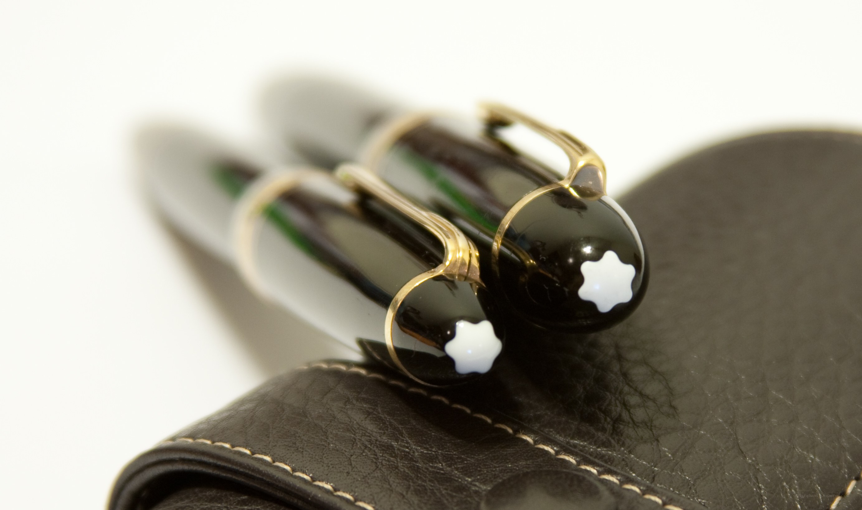 Two black pens on leather