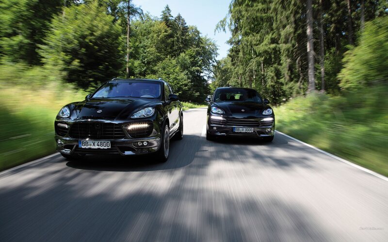 Two black Porsche Cayennes on a forest road
