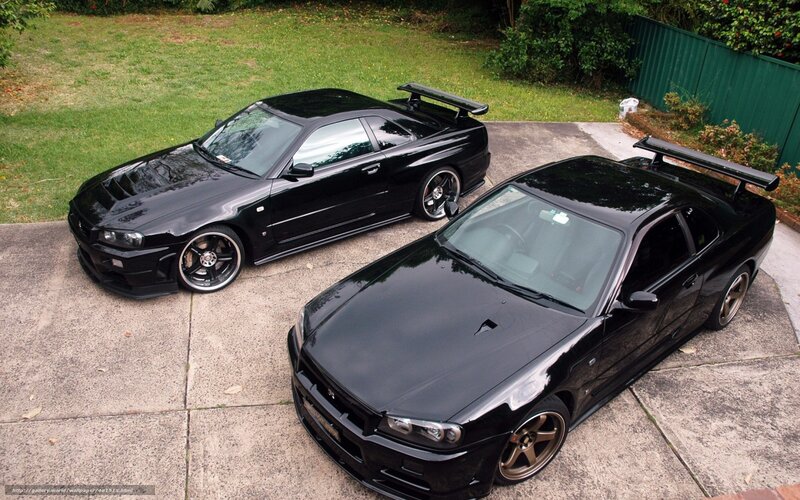 Two black sports cars on driveway