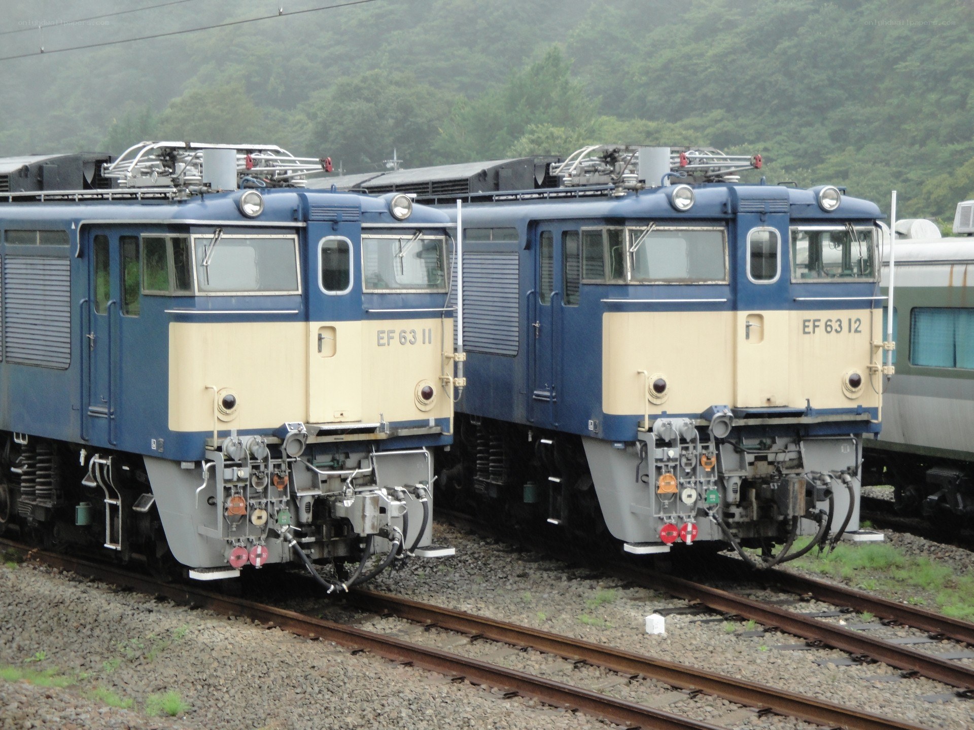 Two blue locomotives on tracks