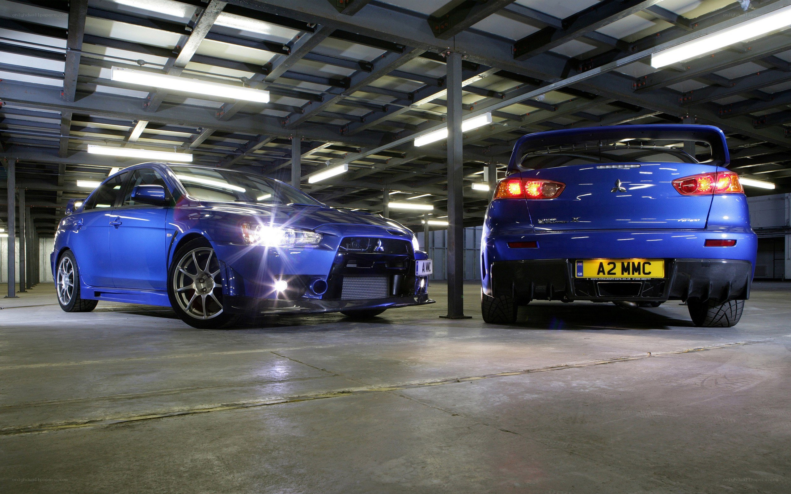 Two blue Mitsubishi Lancers