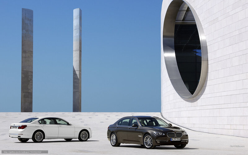 Two BMW 7 Series cars at modern site