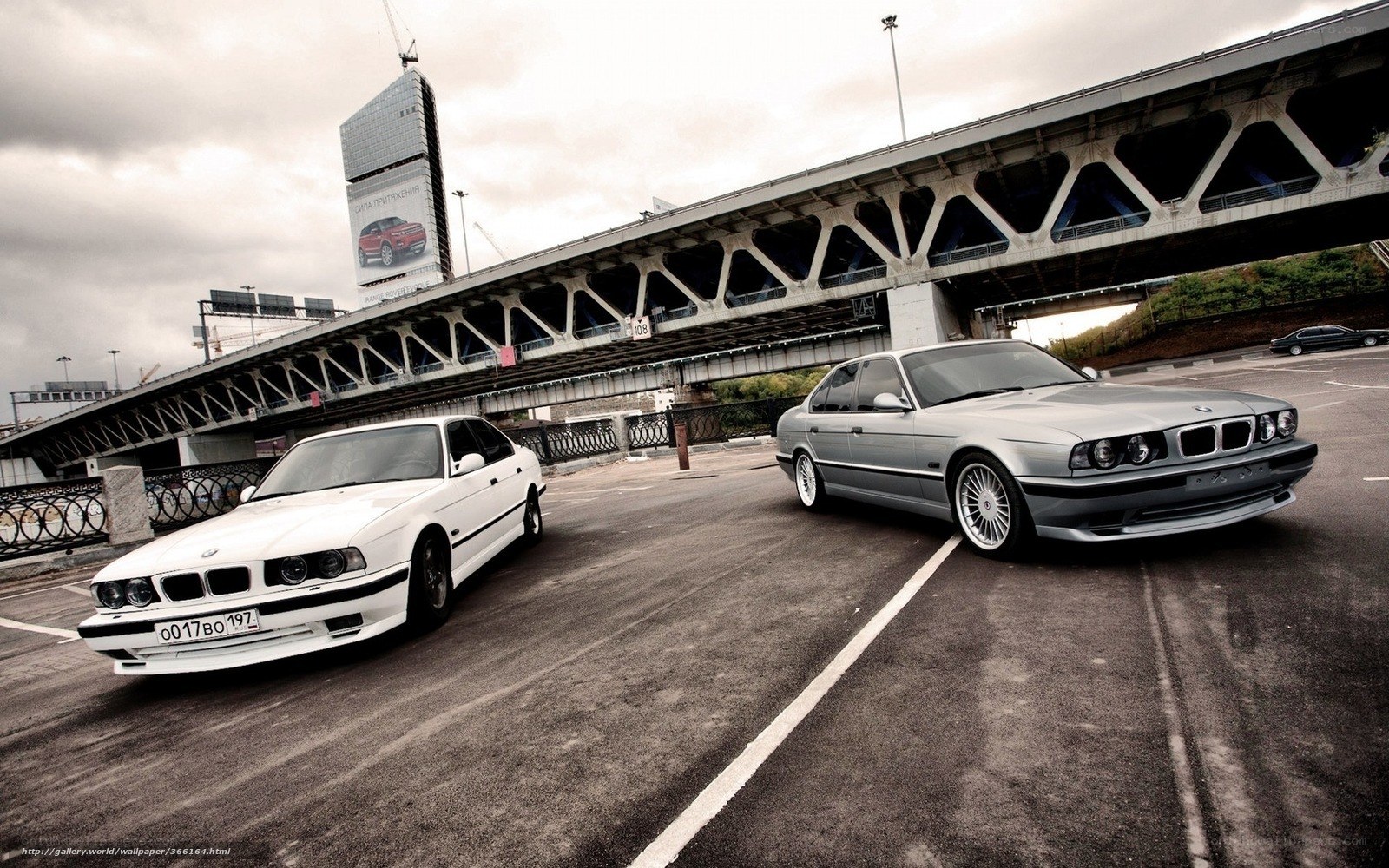Two BMW cars on a bridge