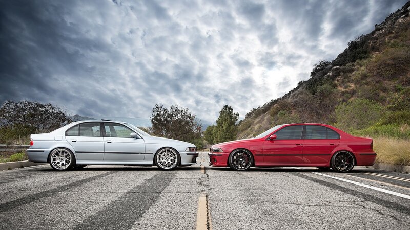 Two BMW cars on a road
