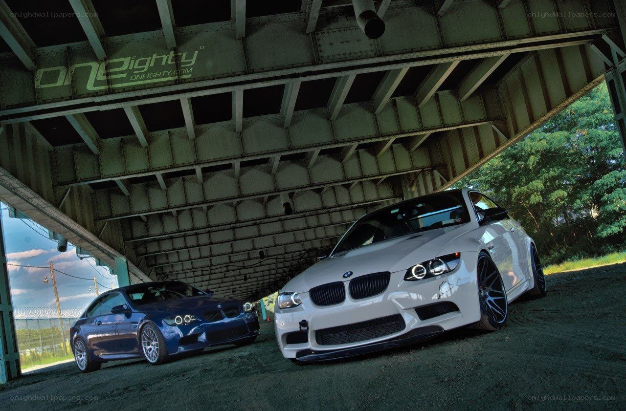 Two BMW cars under a bridge