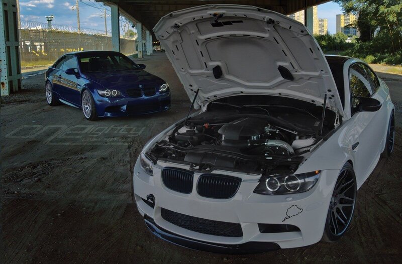 Two BMW M3 cars under a bridge