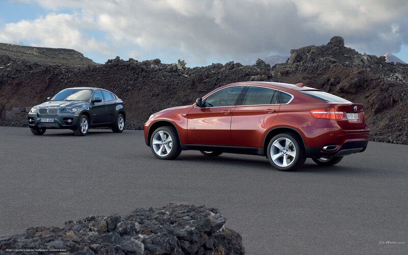 Two BMW SUVs on a volcanic road
