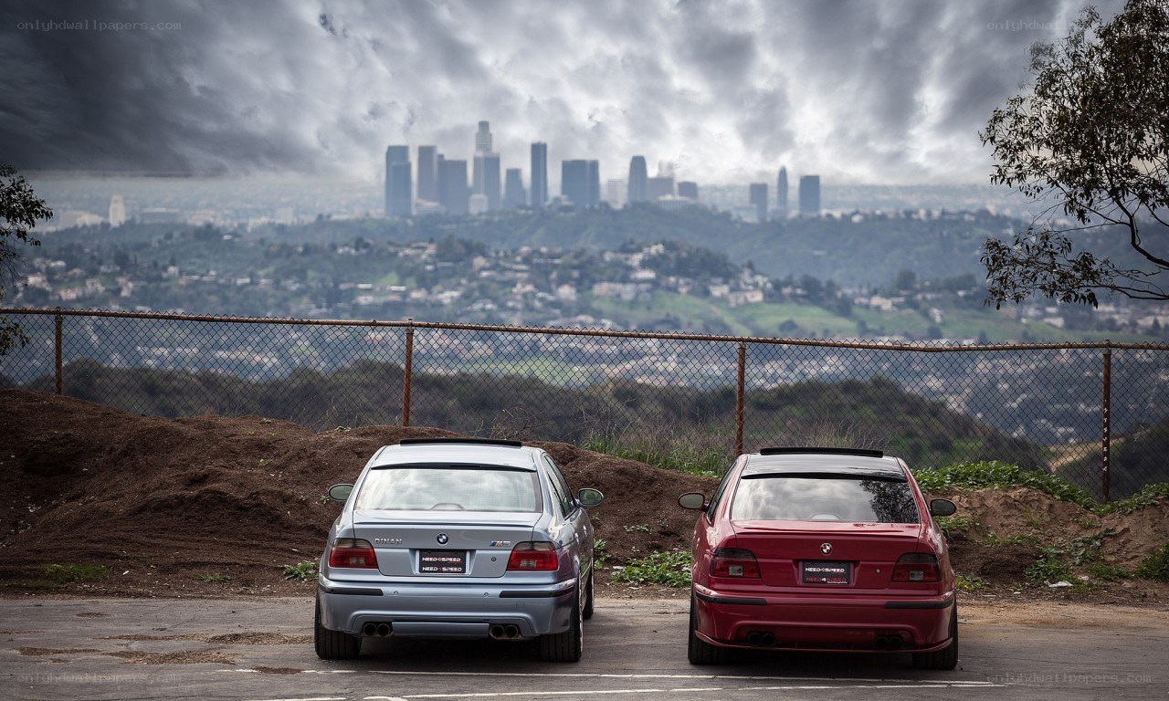 Two BMWs overlooking a city