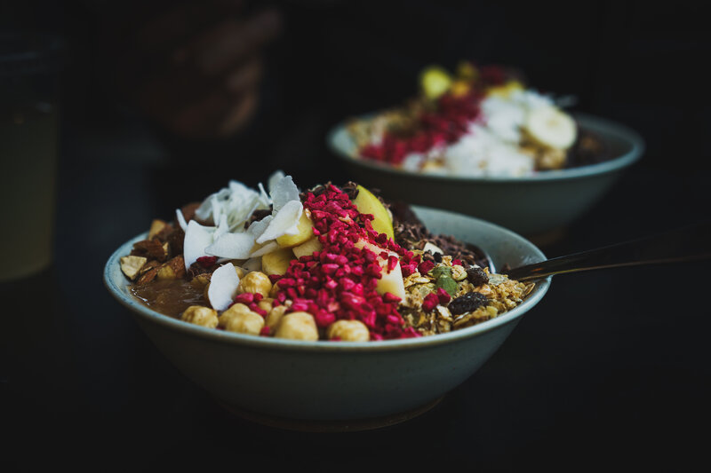 Two bowls of granola and fruit