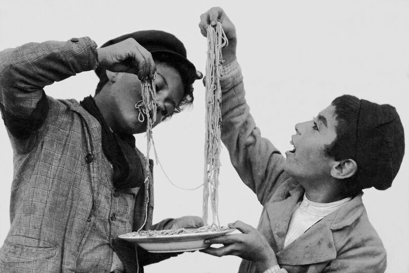 Two boys eating spaghetti