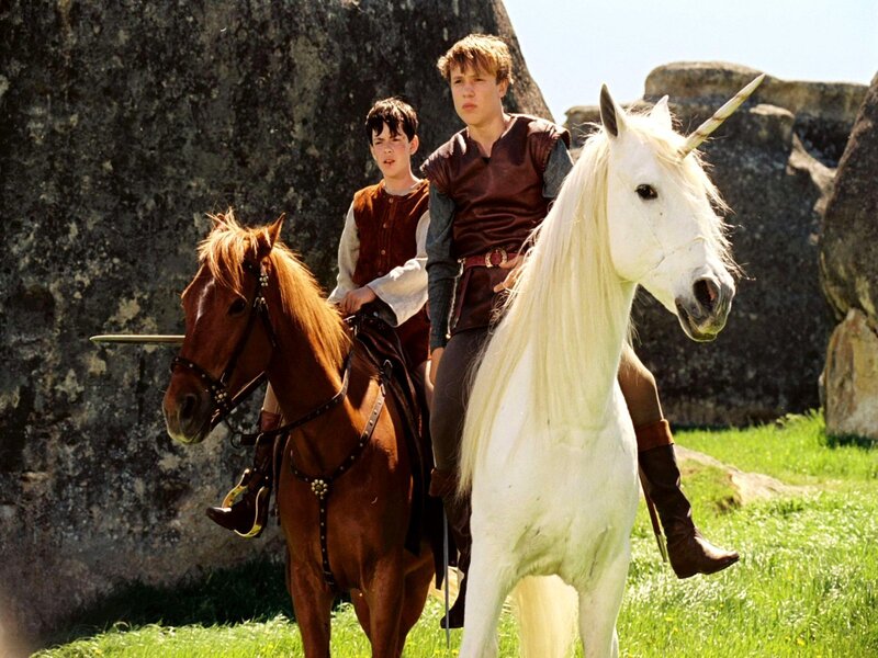 Two boys on horses with a unicorn