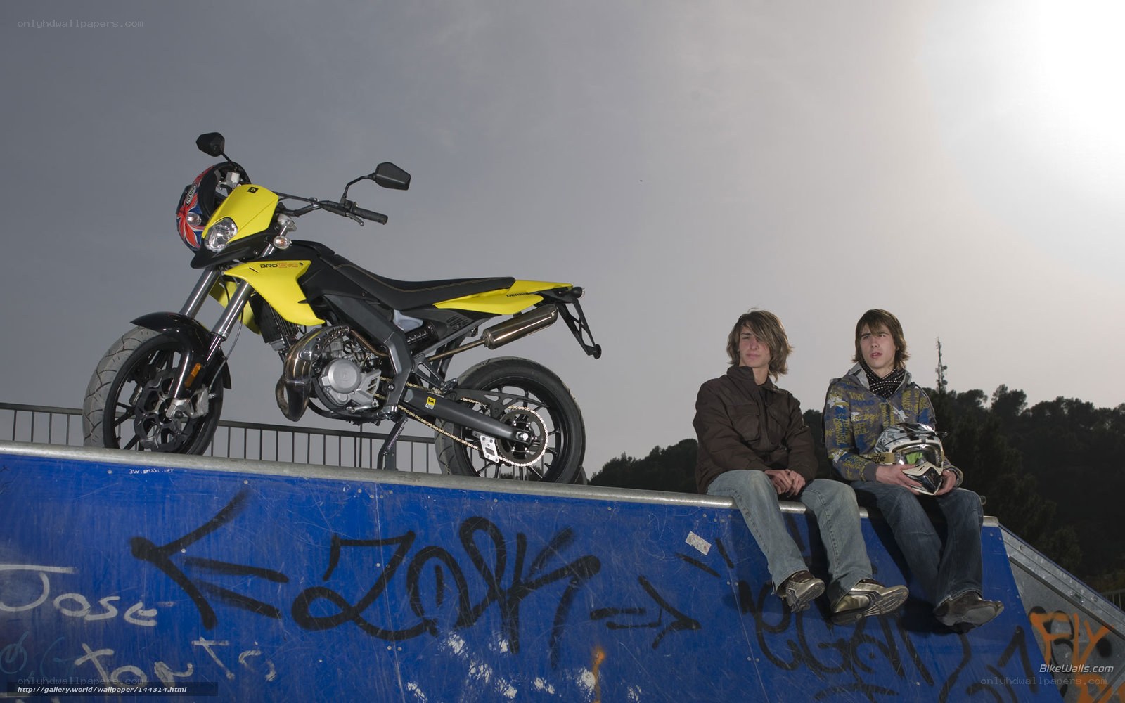 Two boys with a yellow motorcycle