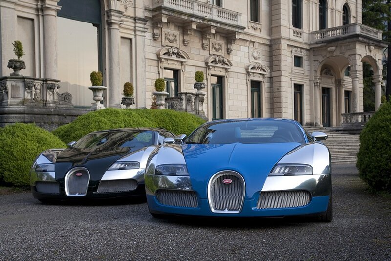 Two Bugatti Veyrons in front of a mansion