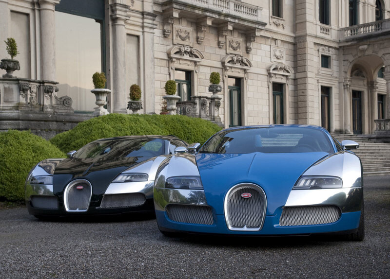Two Bugatti Veyrons in front of a mansion