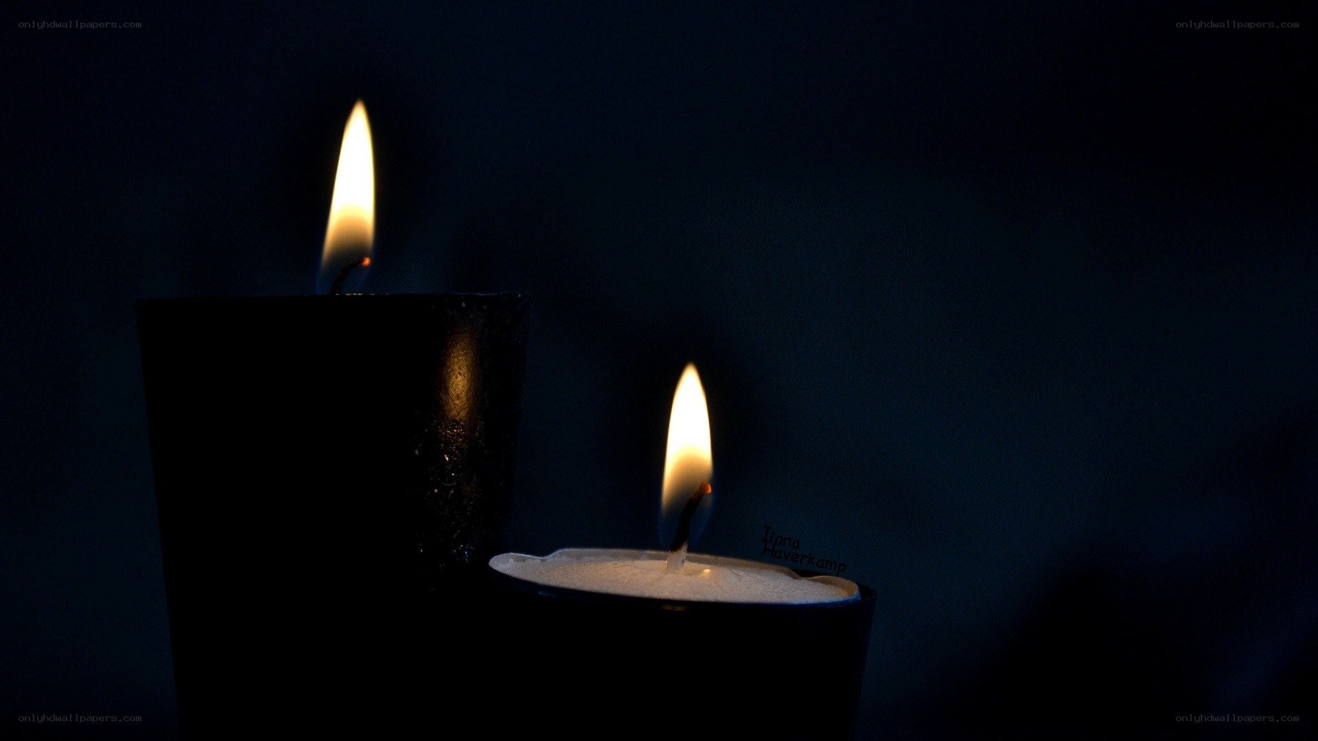 Two candles burning in darkness