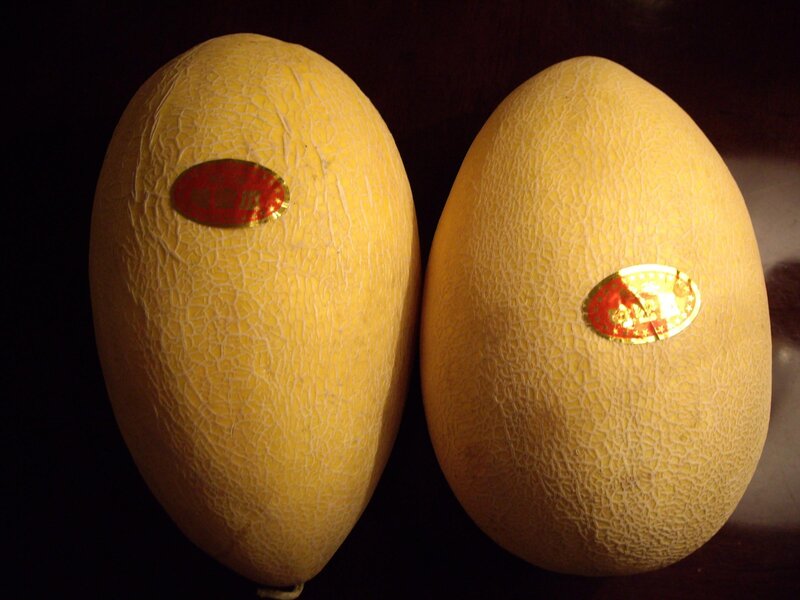 Two cantaloupes with stickers