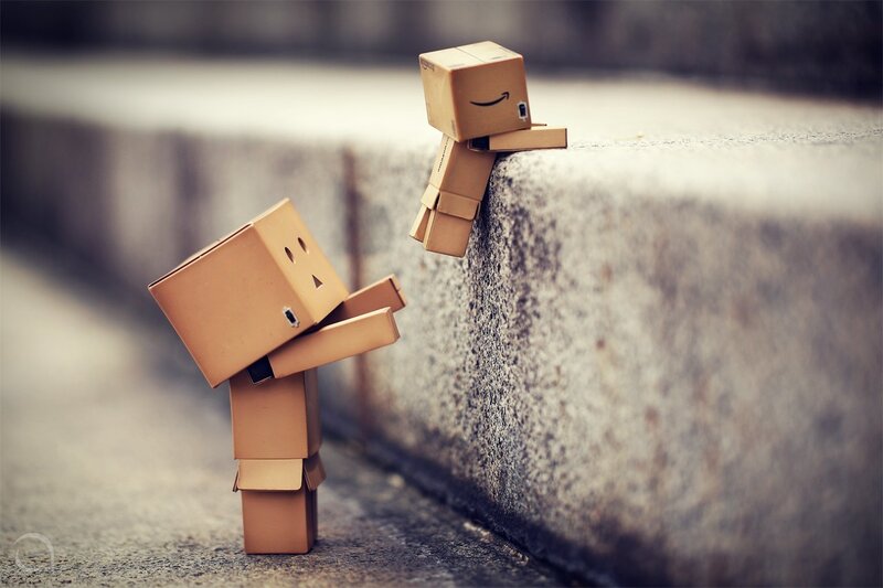 Two cardboard box figures interacting