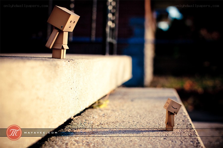 Two cardboard figures on a ledge