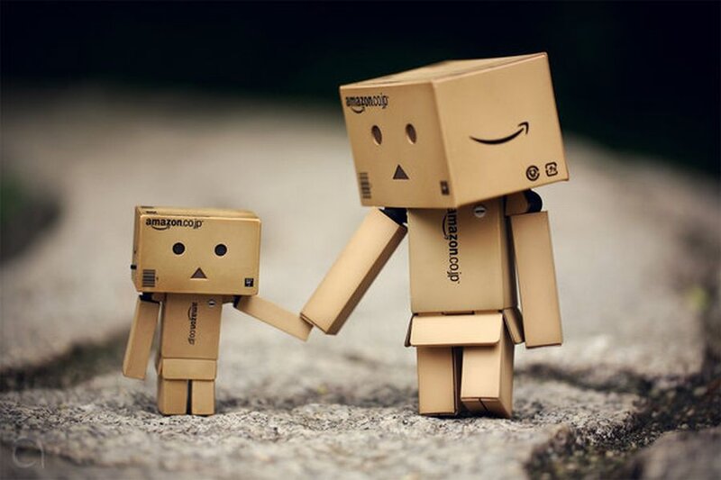Two Cardboard Robots Holding Hands