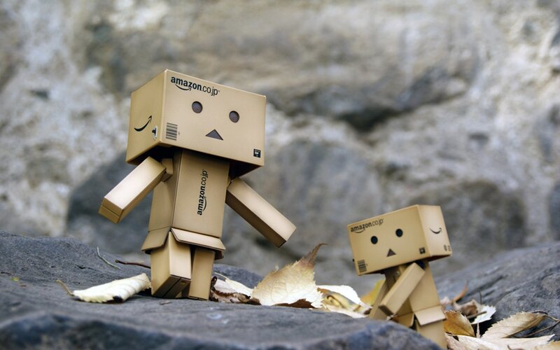 Two cardboard robots on rocks