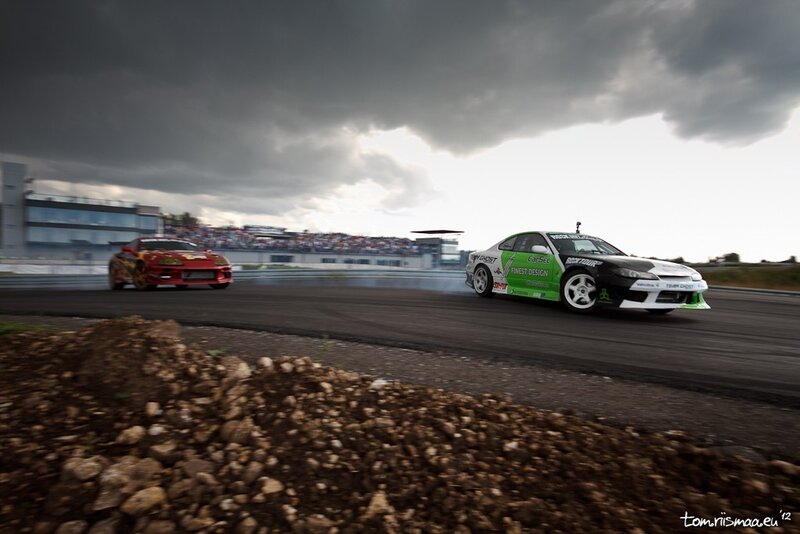 Two cars drifting on a racetrack