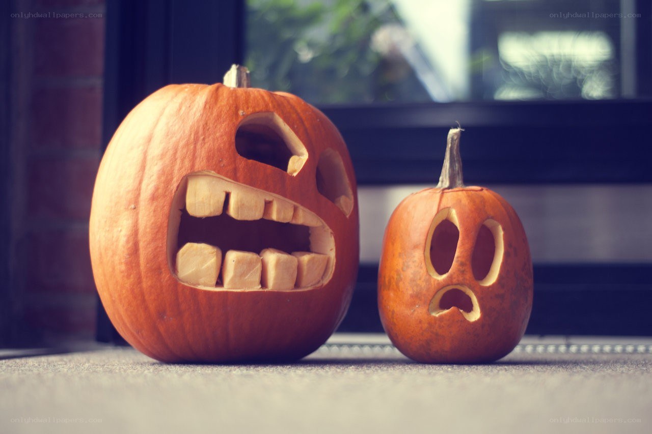 Two carved pumpkins on a doorstep