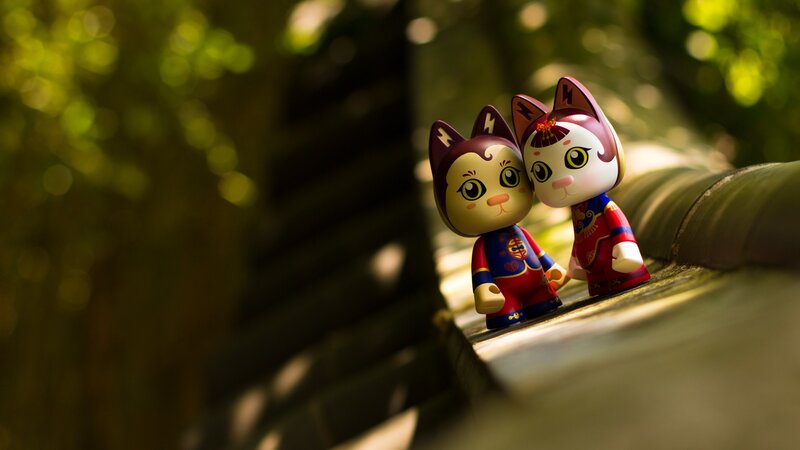 Two cat figurines in traditional attire
