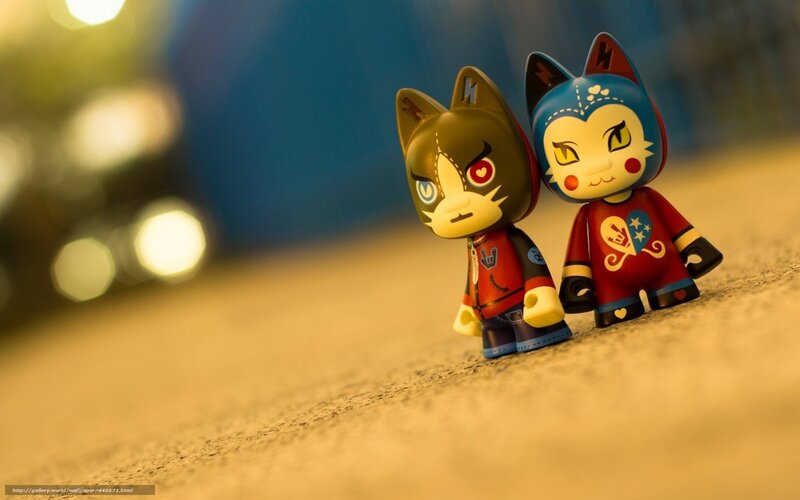 Two cat figurines on pavement