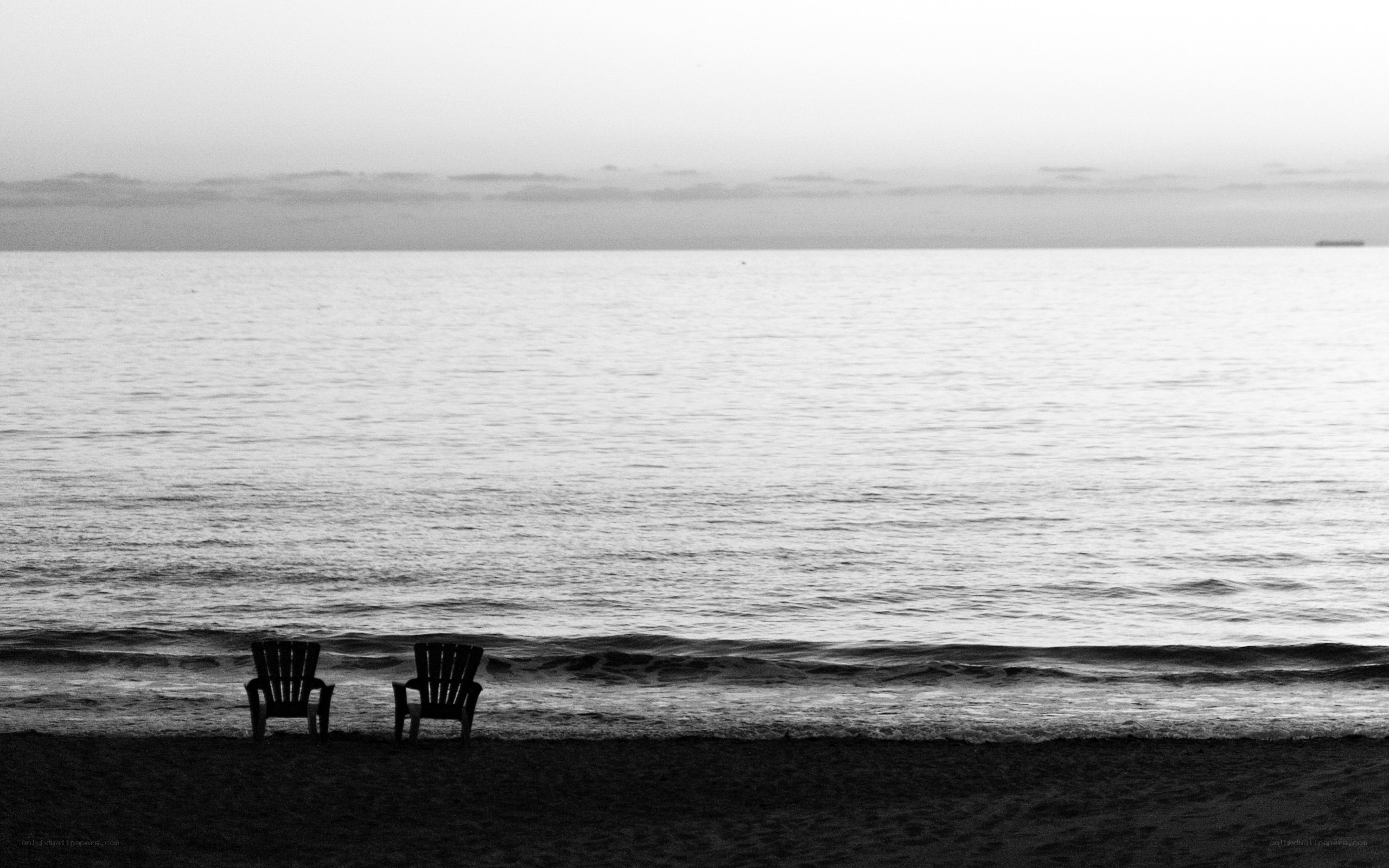 Two chairs on a beach at dusk