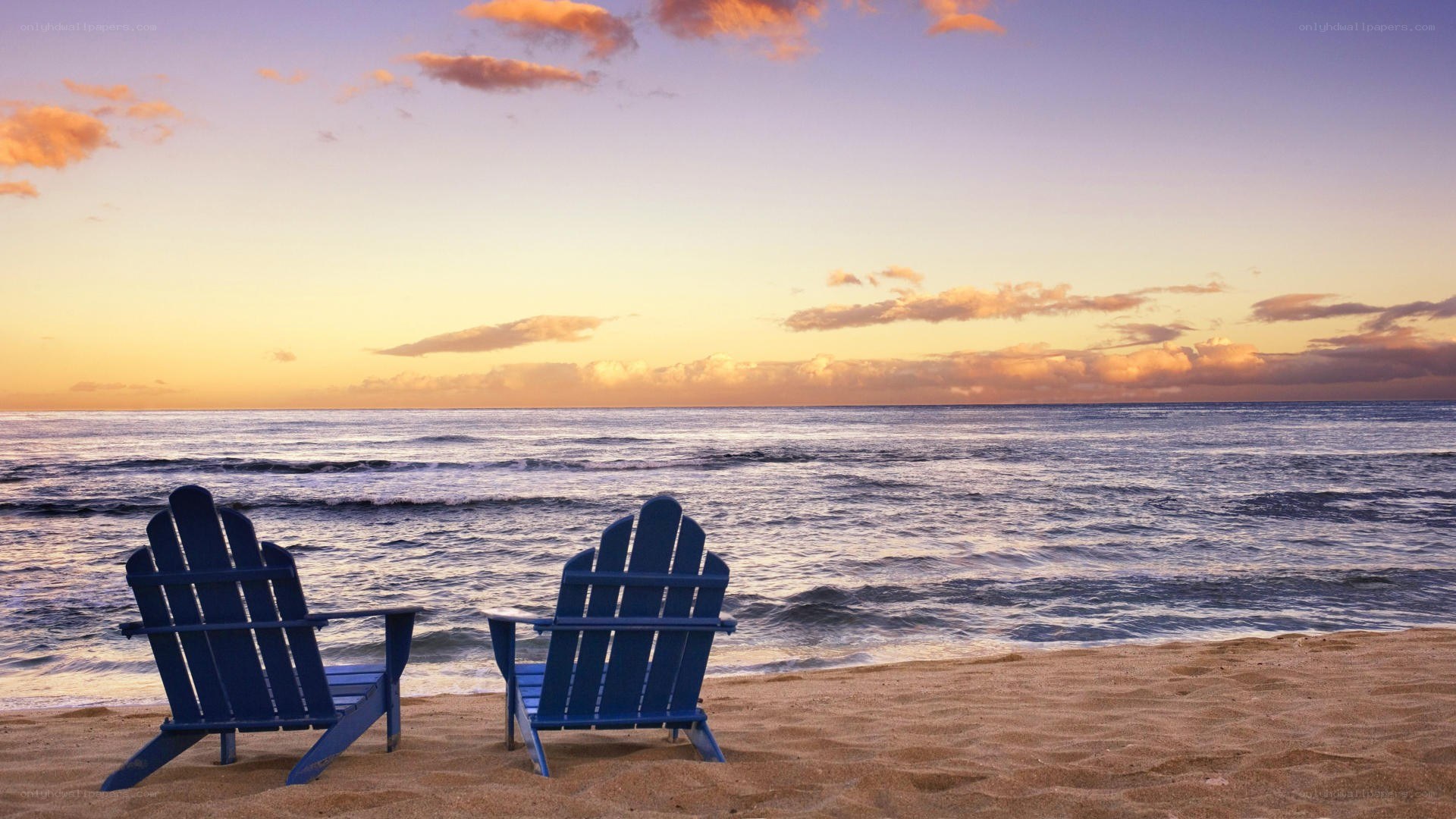 Two chairs on a beach at sunset